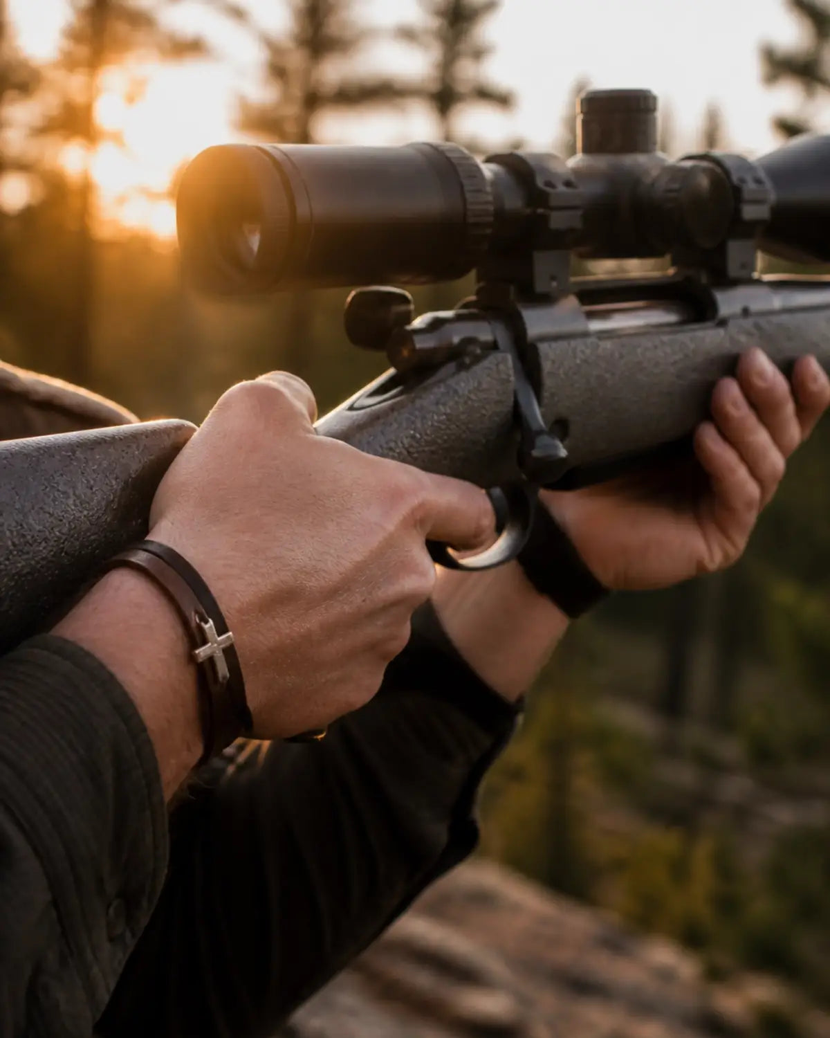 Hands on rifle with cross bracelet